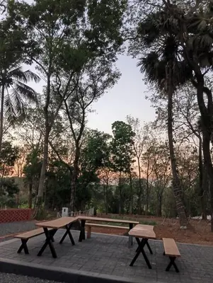 a picnic table and two benches in a park at The Multi Gen Retreat at gaya3farms in Parli