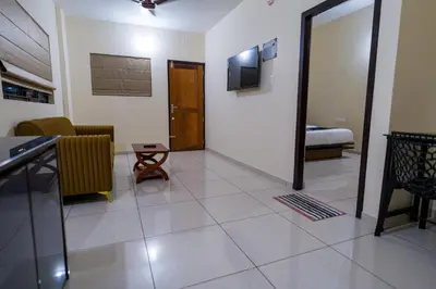 a living room with a couch and a television on a wall at Hotel Aeronest Residency in Calicut