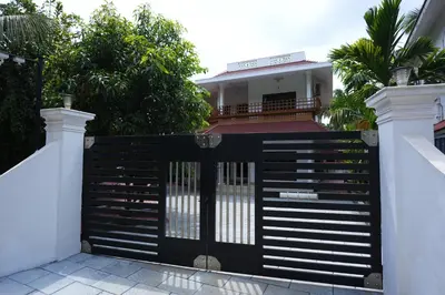 a black gate in front of a house at Guruvayur Nature Homestay in Kunnamkulam