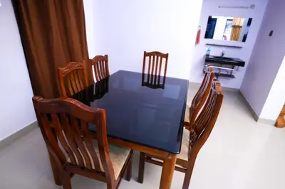 a dining room table with chairs and a blue table at Guruvayur Nature Homestay in Kunnamkulam