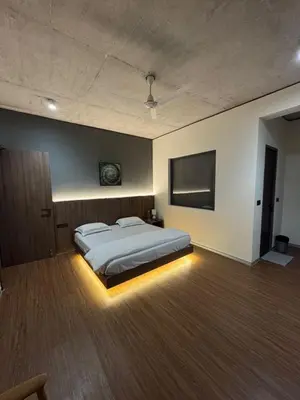 a bedroom with a bed and a flat screen tv at A private room in a luxury villa- The Water's Edge in Kotagiri