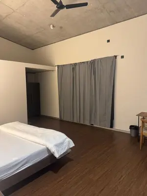 a bedroom with a bed and a ceiling fan at A private room in a luxury villa- The Water's Edge in Kotagiri