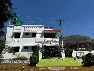 a white building with a garden in front of it at Amaravathi home stay