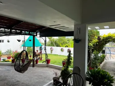 a patio with a blue umbrella and some plants at Amaravathi home stay