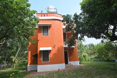 a red brick building with a lighthouse on it at Nisarga Greens in Chittūr