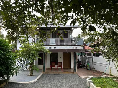 a house with two chairs in front of it at Ravi's homestay in Cochin