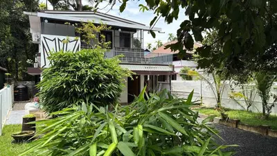 a house with a bunch of plants in front of it at Ravi's homestay in Cochin