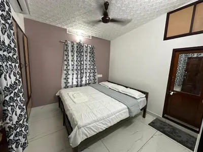 a small bedroom with a bed and a ceiling at Ravi's homestay in Cochin