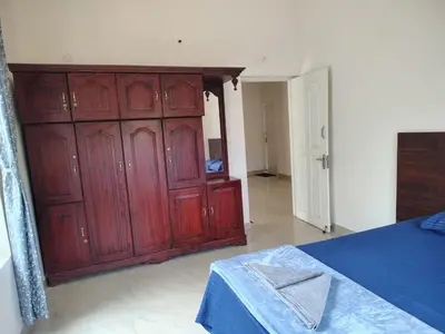 a bedroom with red wooden cabinets and a blue table at Sintra Villa in Meppādi