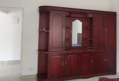 a wooden cabinet with a mirror in a room at Sintra Villa in Meppādi