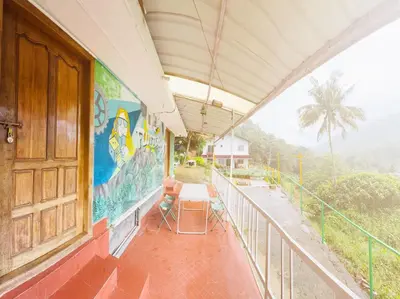 a balcony of a building with a mural on the wall at Greenwoods Mist Villa in Munnar
