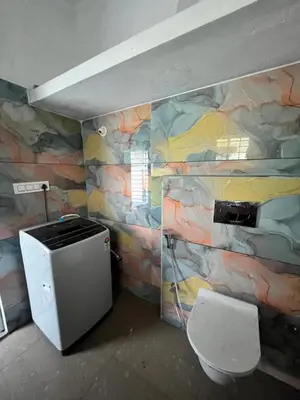 a bathroom with a rock wall with a toilet at Chamundi Temple-Hill View in Mysore
