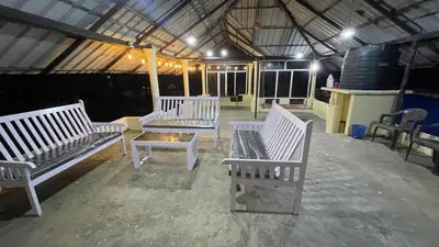 a group of white benches sitting inside of a building at Vibgyor home stay in Pallipuram