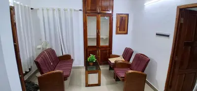 a waiting room with purple chairs and a glass table at Vibgyor home stay in Pallipuram