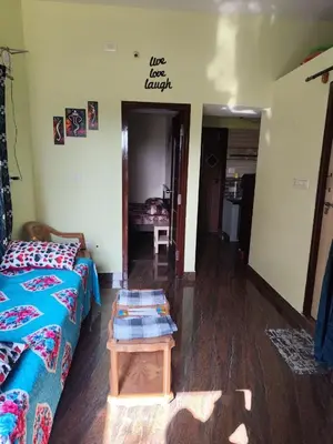 a living room with a couch and a table at My Sooru - Spacious 2BHK Homely Retreat in Mysore