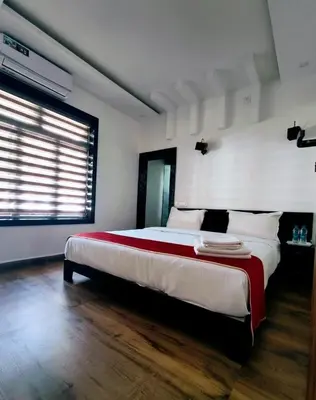 a bedroom with a large bed and a window at Forest edge Villa - 3 bedrooms in Ambalavayal