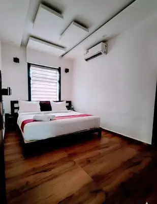a bedroom with a large bed with a wooden floor at Forest edge Villa - 3 bedrooms in Ambalavayal