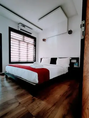 a bedroom with a large bed with a red blanket at Forest edge Villa - 3 bedrooms in Ambalavayal