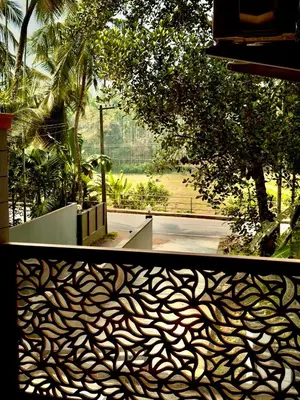 a view of a garden from behind a metal fence at Sawan Home stay - 2 BHK fully furnished in Kozhikode