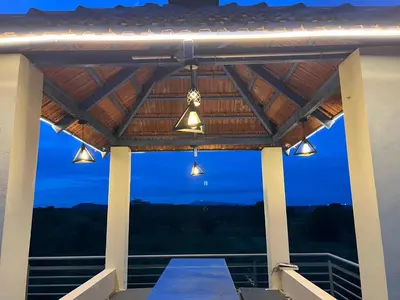 a covered porch with lights and a blue sky at Rivora Retreat in Nanjangūd