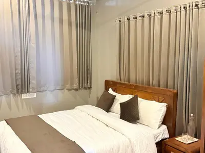 a bedroom with a bed with white sheets and pillows at Valensa lake view in Kalpetta