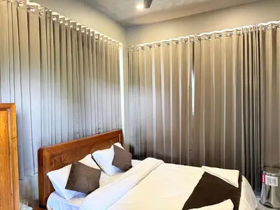 a bedroom with a bed with white sheets and pillows at Valensa lake view in Kalpetta
