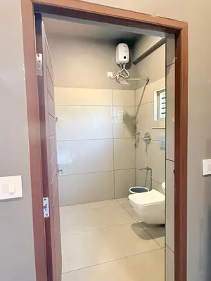 a bathroom with a shower and a toilet at Valensa lake view in Kalpetta