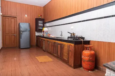 a kitchen with a sink and a refrigerator at Wayanad home stay in Vythiri