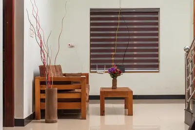 a room with a chair and a table and a window at Wayanad home stay in Vythiri