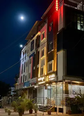 a building with a sign on the side of it at night at Amara Grand in Mysore
