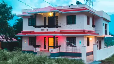 a white house with a red roof at Dew drops Marayoor in Kanthalloor
