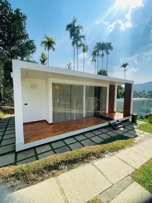a modern house with a deck with palm trees at West wind Resort in Meppādi