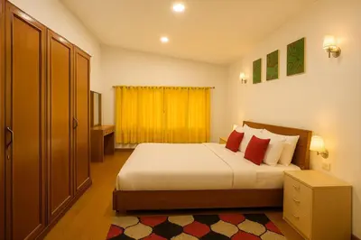a bedroom with a bed and a yellow curtain at Secret Escape Heritage Bungalow in Ooty