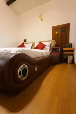 a bedroom with a large bed with a wooden floor at Secret Escape Heritage Bungalow in Ooty