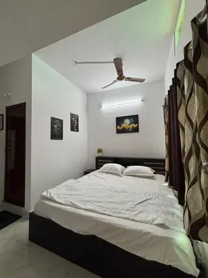 a bedroom with a large bed with a ceiling fan at Arranyaa retreatt- Girrafe's gallery in Mysore