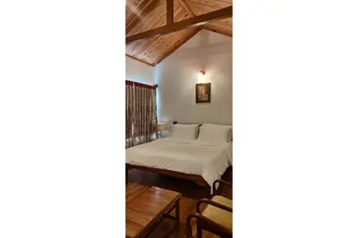 a bedroom with a bed and a table at Brooklyn Villa in Ooty