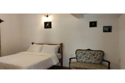 a hotel room with a bed and a chair at Brooklyn Villa in Ooty