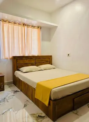 a bedroom with a bed with a yellow blanket on it at Neelees Retreat in Kaniyāmbetta