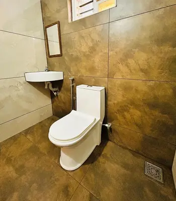 a bathroom with a toilet and a sink at Neelees Retreat in Kaniyāmbetta