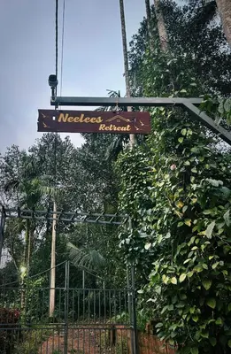 a street sign hanging from a fence at Neelees Retreat in Kaniyāmbetta