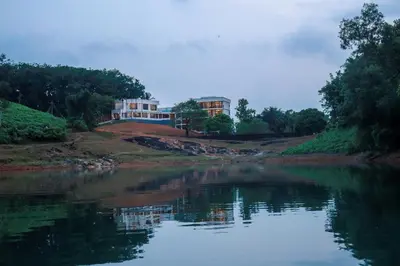 a house on a hill next to a body of water at Serene Aqua Hills in Kozhikode