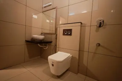 a small bathroom with a toilet and a shower at Serene Aqua Hills in Kozhikode
