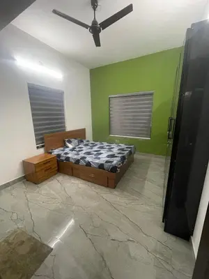 a bedroom with a bed and a ceiling fan at Mountholidays in Meppādi