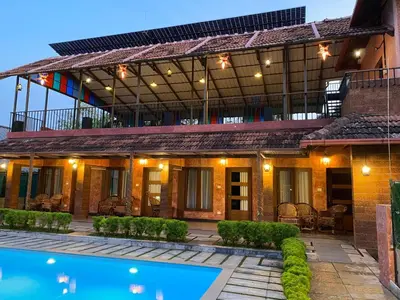 a house with a swimming pool in front of it at Ponyo Stays in Cochin