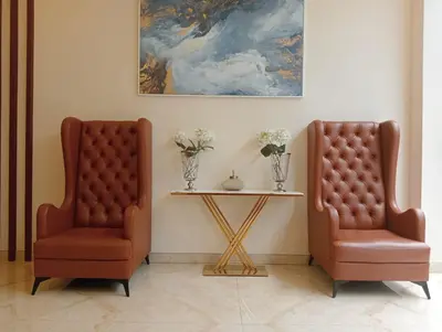 two chairs sitting next to a table with a painting at Aloka Cordial Luxury Residences in Trichūr