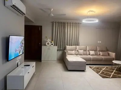 a living room with a couch and a flat screen tv at Aloka Cordial Luxury Residences in Trichūr