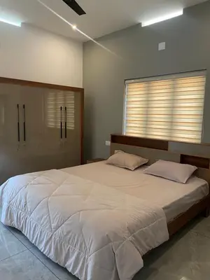 a bedroom with a large white bed and a window at Vijay Home Stays in Batheri