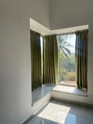 a room with a large window with green curtains at Vijay Home Stays in Batheri