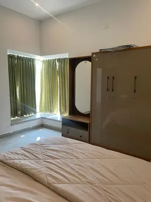 a bedroom with a large bed and a large mirror at Vijay Home Stays in Batheri