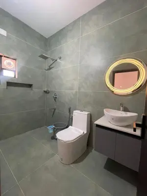 a bathroom with a toilet and a sink and a mirror at Vijay Home Stays in Batheri